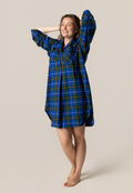 Woman wearing a nova scotia tartan nightshirt against a beige background
