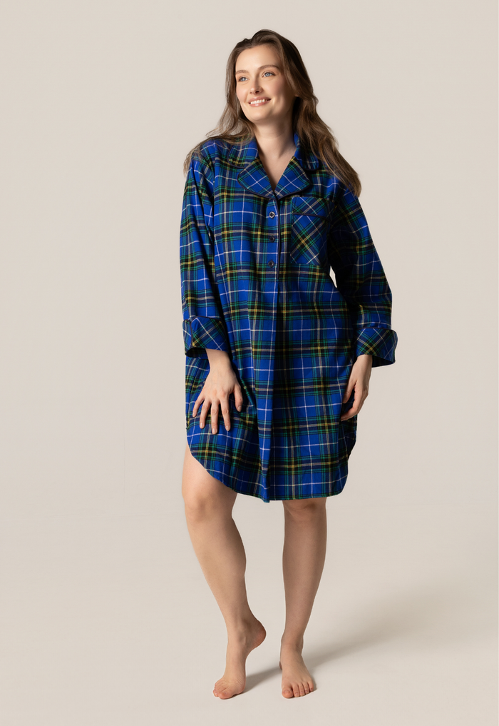 Woman wearing a blue plaid nightshirt against a plain background