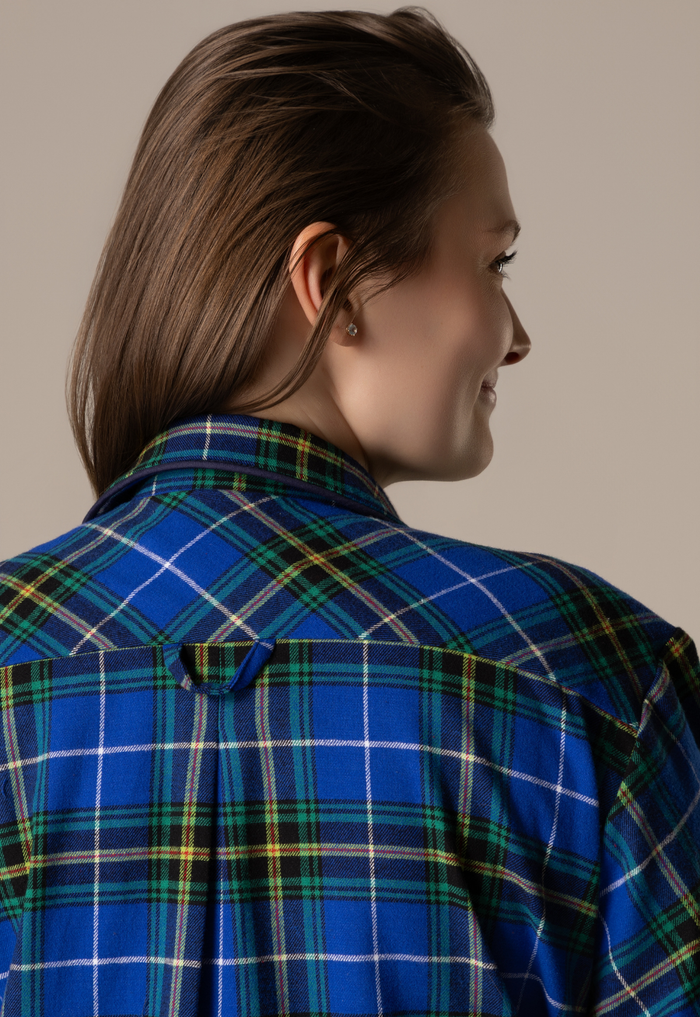 Person wearing a blue plaid nightgown against a neutral background