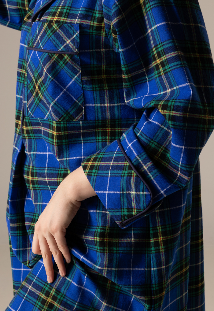 Nova scotia tartan nightshirt with a hand adjusting the collar against a neutral background