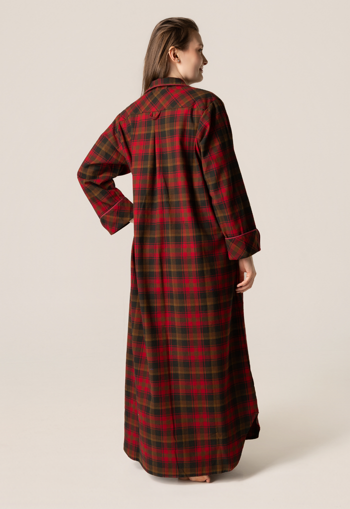 Person wearing a red and green plaid dress against a beige background