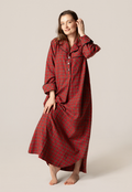 Woman wearing a red plaid nightgown against a plain background