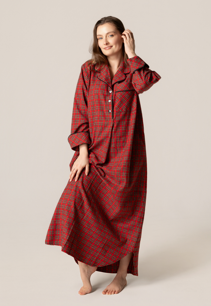 Woman wearing a red plaid nightgown against a plain background