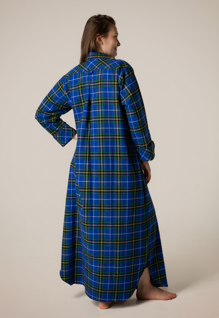 Person wearing a blue plaid nightgown against a beige background
