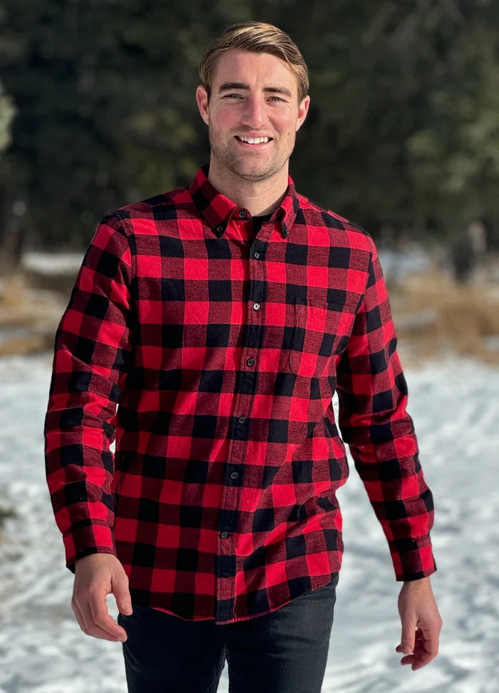 A man wearing a classic Canadian red and black buffalo check button-down shirt with a single pocket on the chest. This shot is taken in Banff National Park