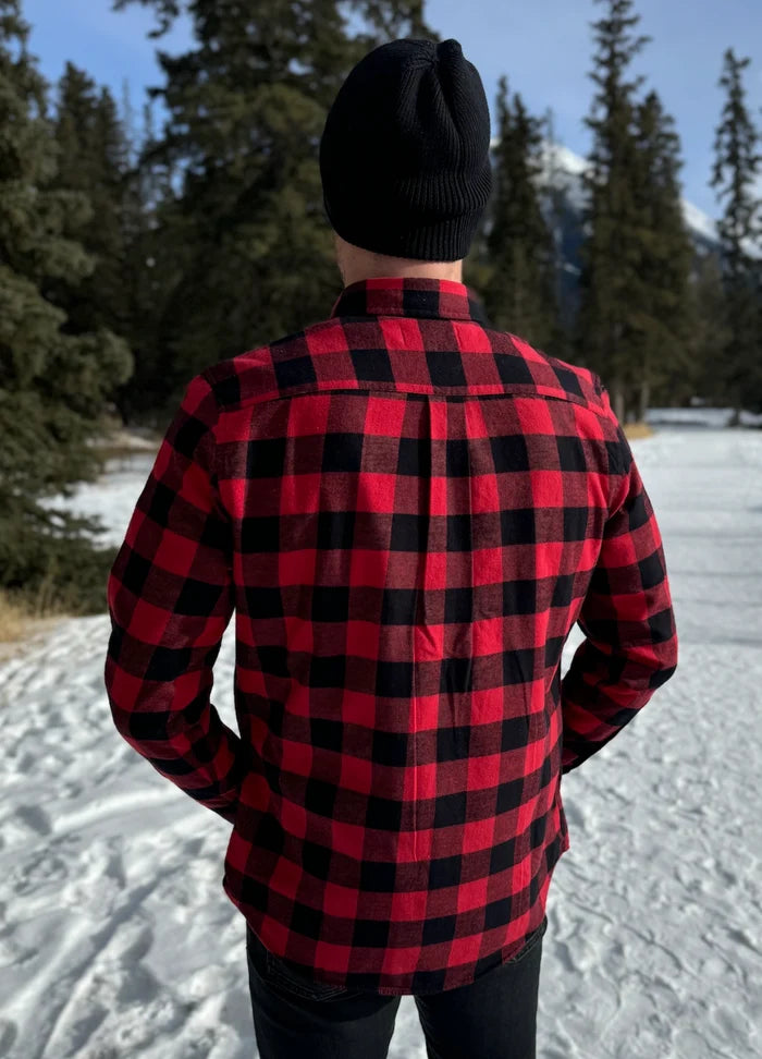 Back view of a man wearing a classic Canadian red and black buffalo check button-down shirt with a single pocket on the chest.