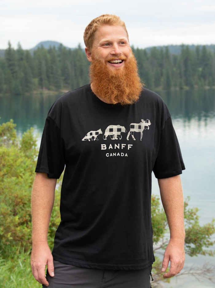 Man wearing a black 'Banff Canada' t-shirt with a scenic background