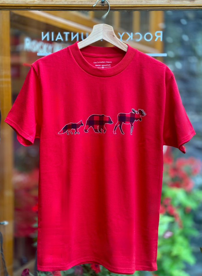 Red t-shirt with bear family graphic on a hanger in front of a store window.