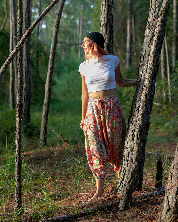 Woman posing in forest wearing red galactic MC Hammer pants #color_Red Galactic
